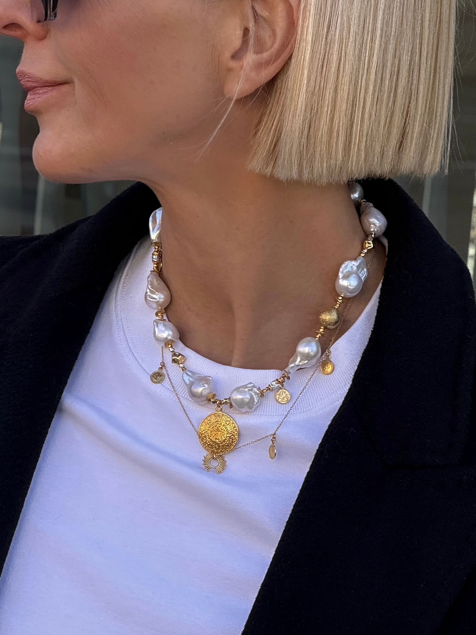 Detal naszyjnika z białych pereł barokowych na modelce