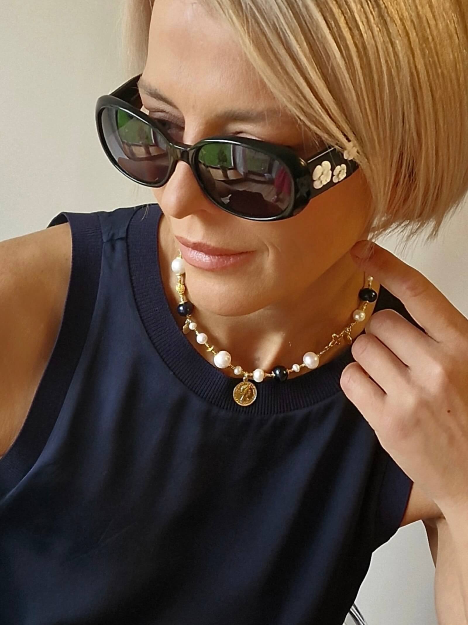 Zbliżenie na naszyjnik z białych i czarnych pereł na modelce
