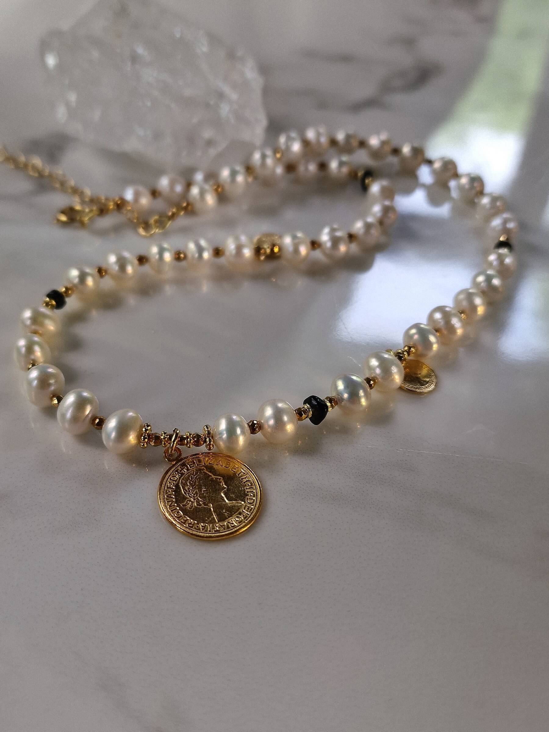 Packshot naszyjnika z naturalnych pereł z monetą