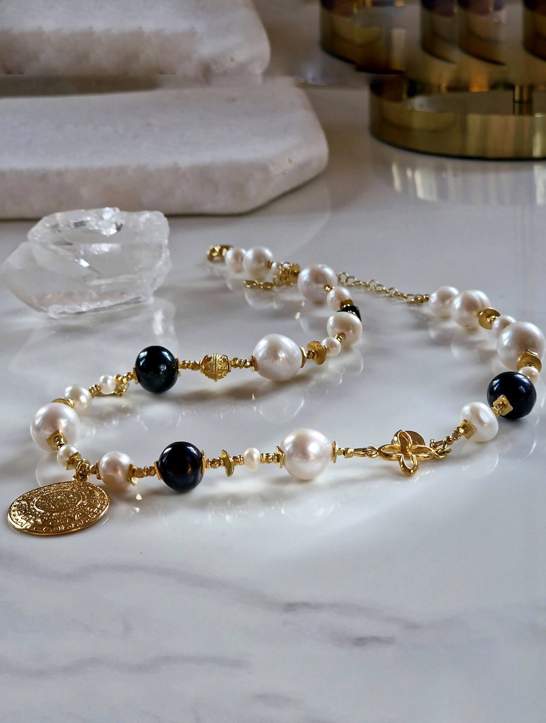 Packshot naszyjnika z białych i czarnych pereł z monetą Azteków – ULASIENICKA