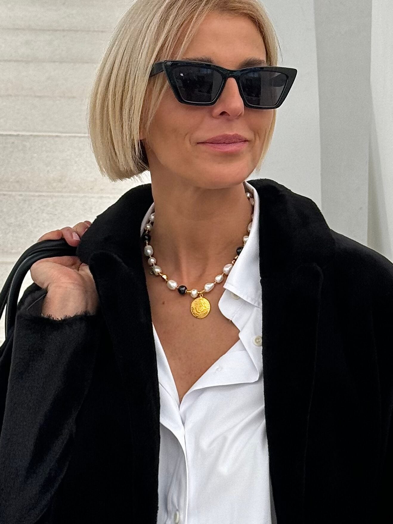 Zbliżenie na naszyjnik z nieregularnych białych i czarnych pereł na modelce