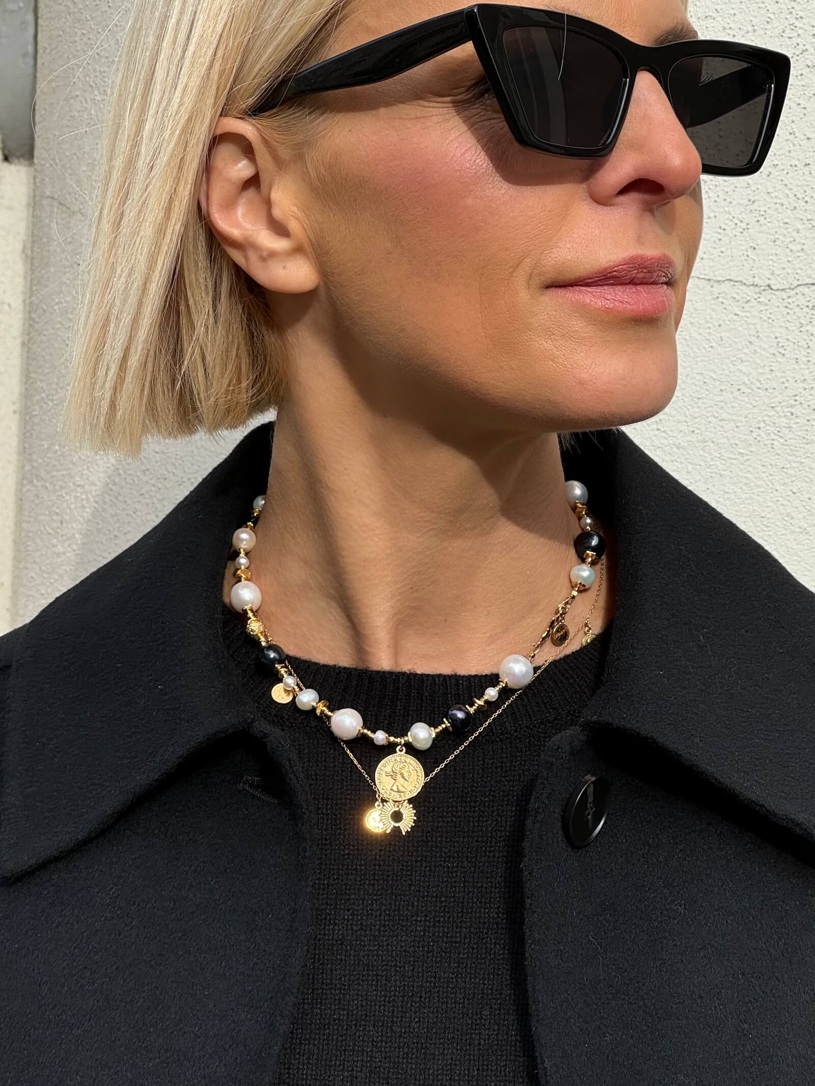 Zbliżenie na naszyjnik z białych i czarnych pereł na modelce