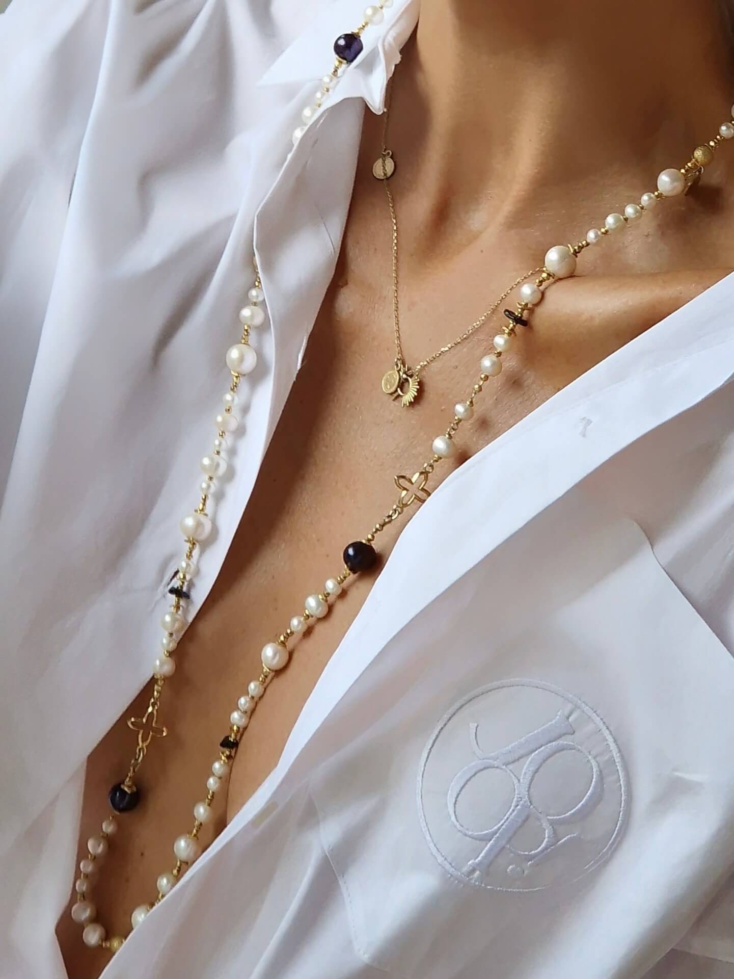 Zbliżenie na długi naszyjnik z czarnych i białych pereł na modelce