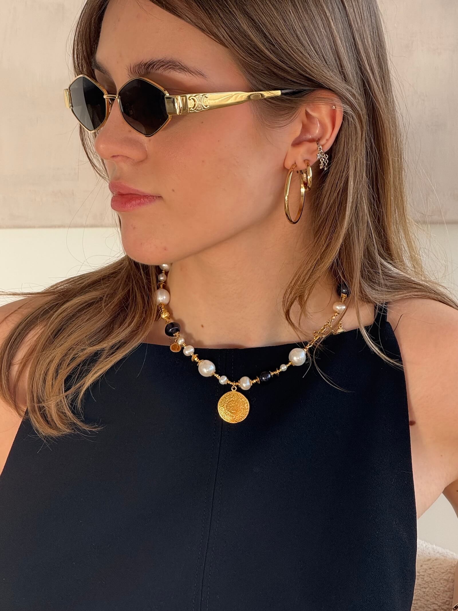 Zbliżenie na naszyjnik z białych i czarnych pereł na modelce