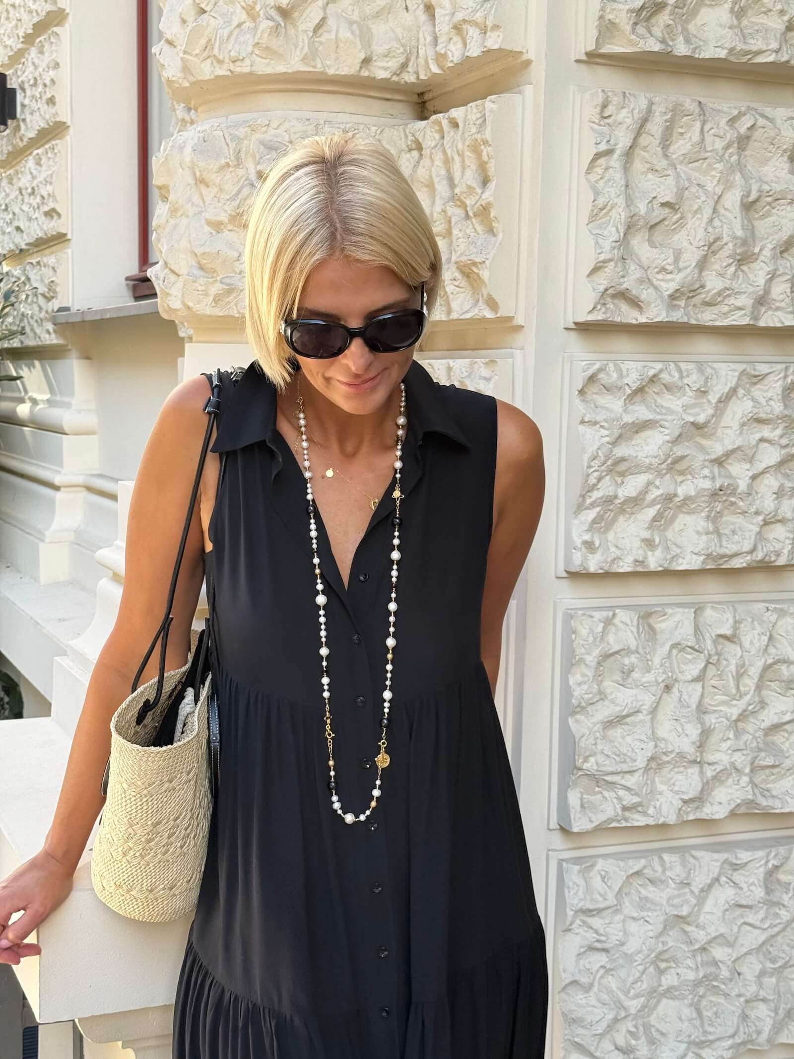 Długi naszyjnik z czarnych i białych pereł jako element pełnej stylizacji