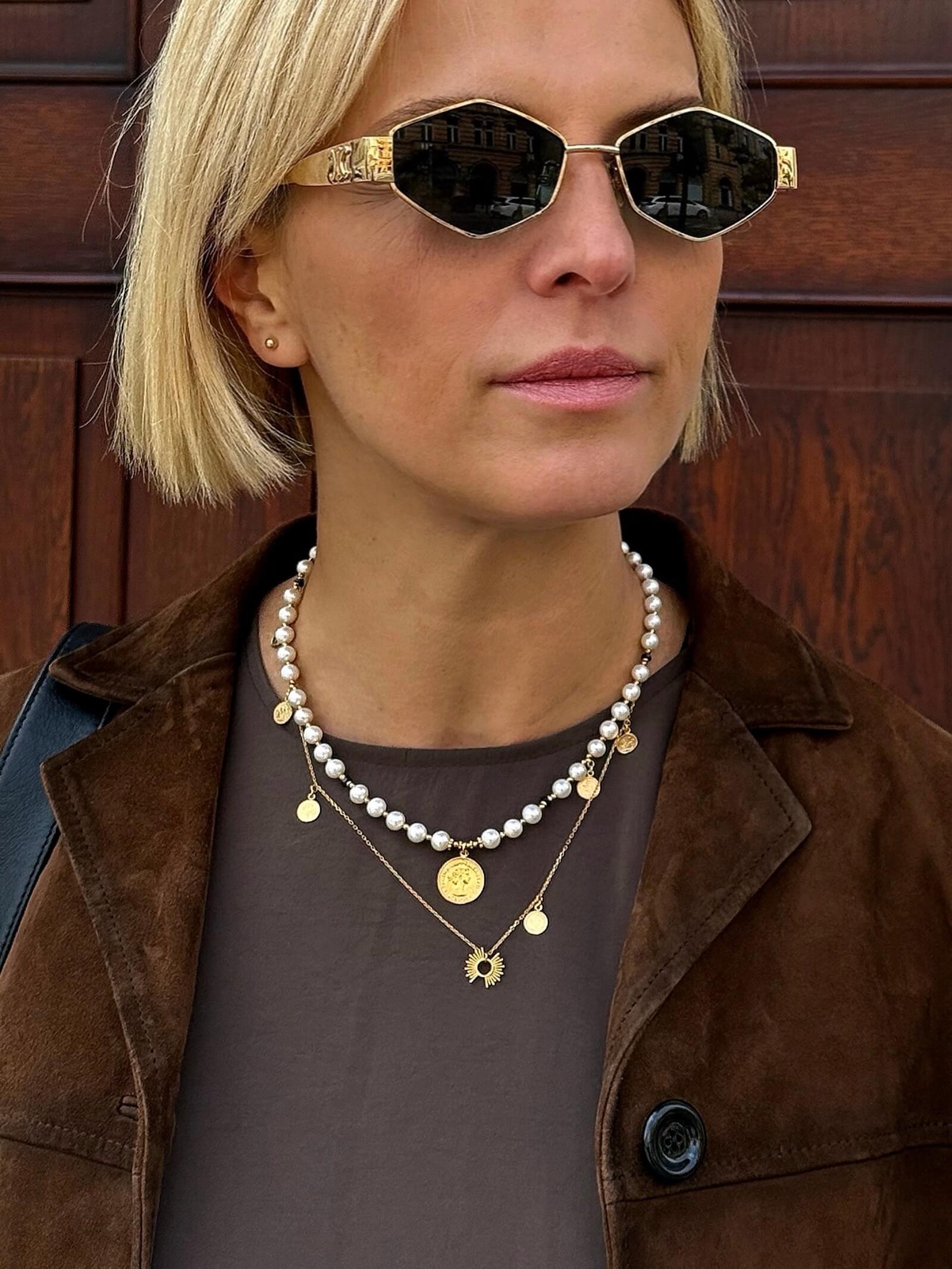 Zbliżenie na naszyjnik z naturalnych pereł na modelce