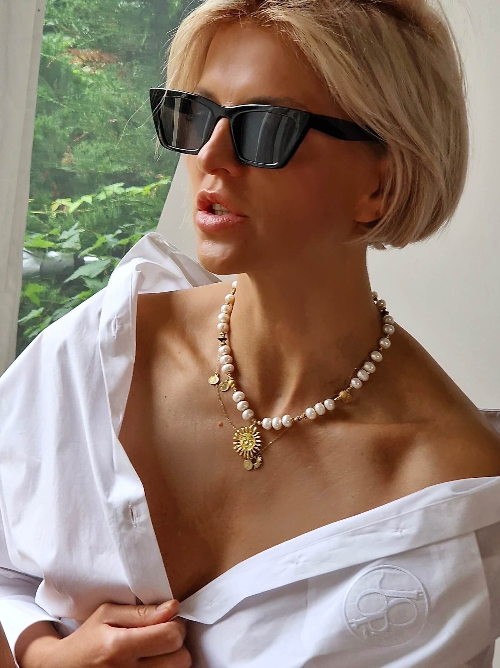 Zbliżenie na naszyjnik z białych pereł na modelce