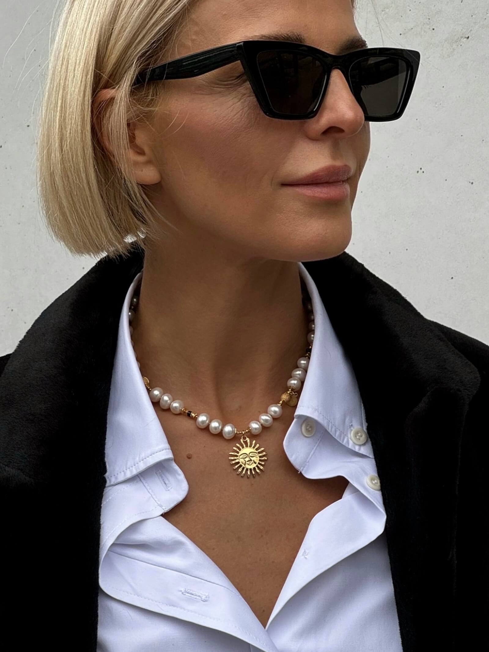 Zbliżenie na naszyjnik z białych pereł na modelce