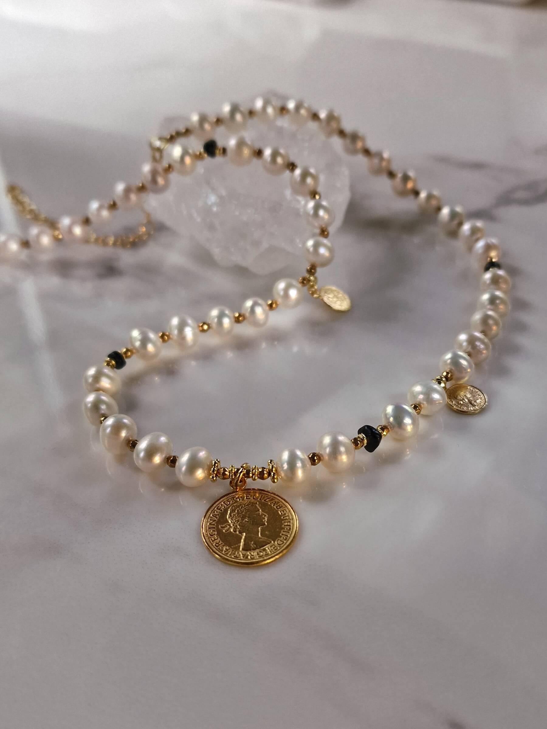 Packshot naszyjnika z naturalnych pereł z monetą