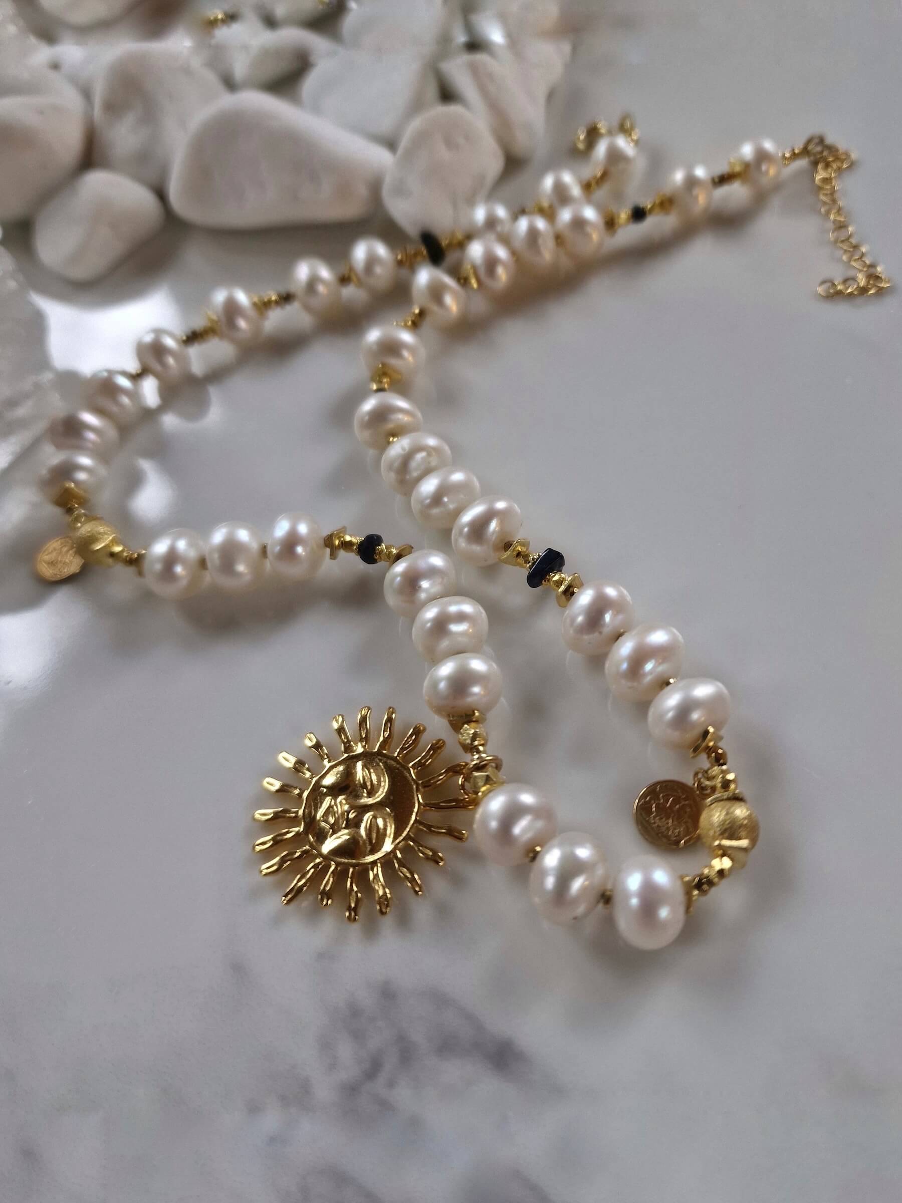 Packshot naszyjnika z białych pereł z zawieszką Słońce