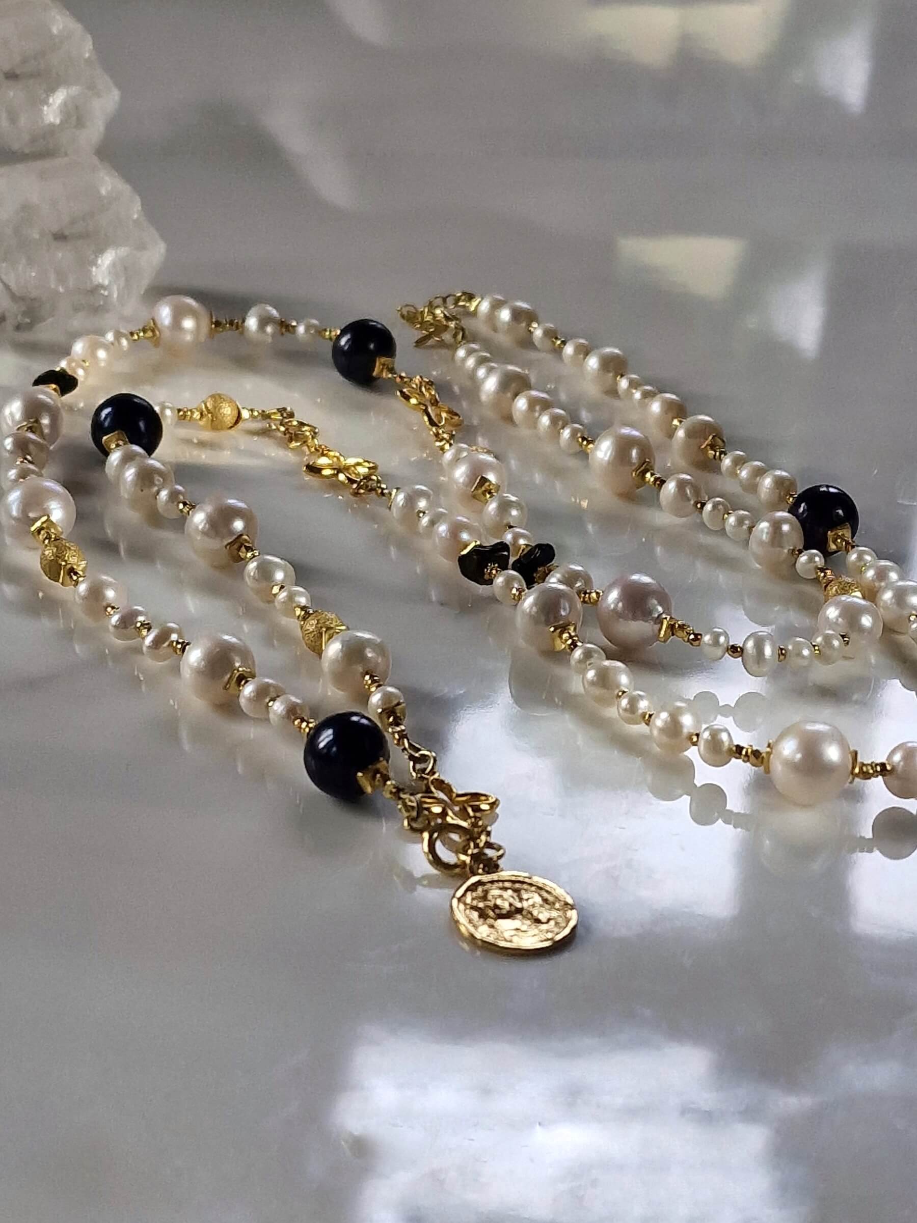 Packshot długiego naszyjnika z czarnych i białych pereł z bransoletką