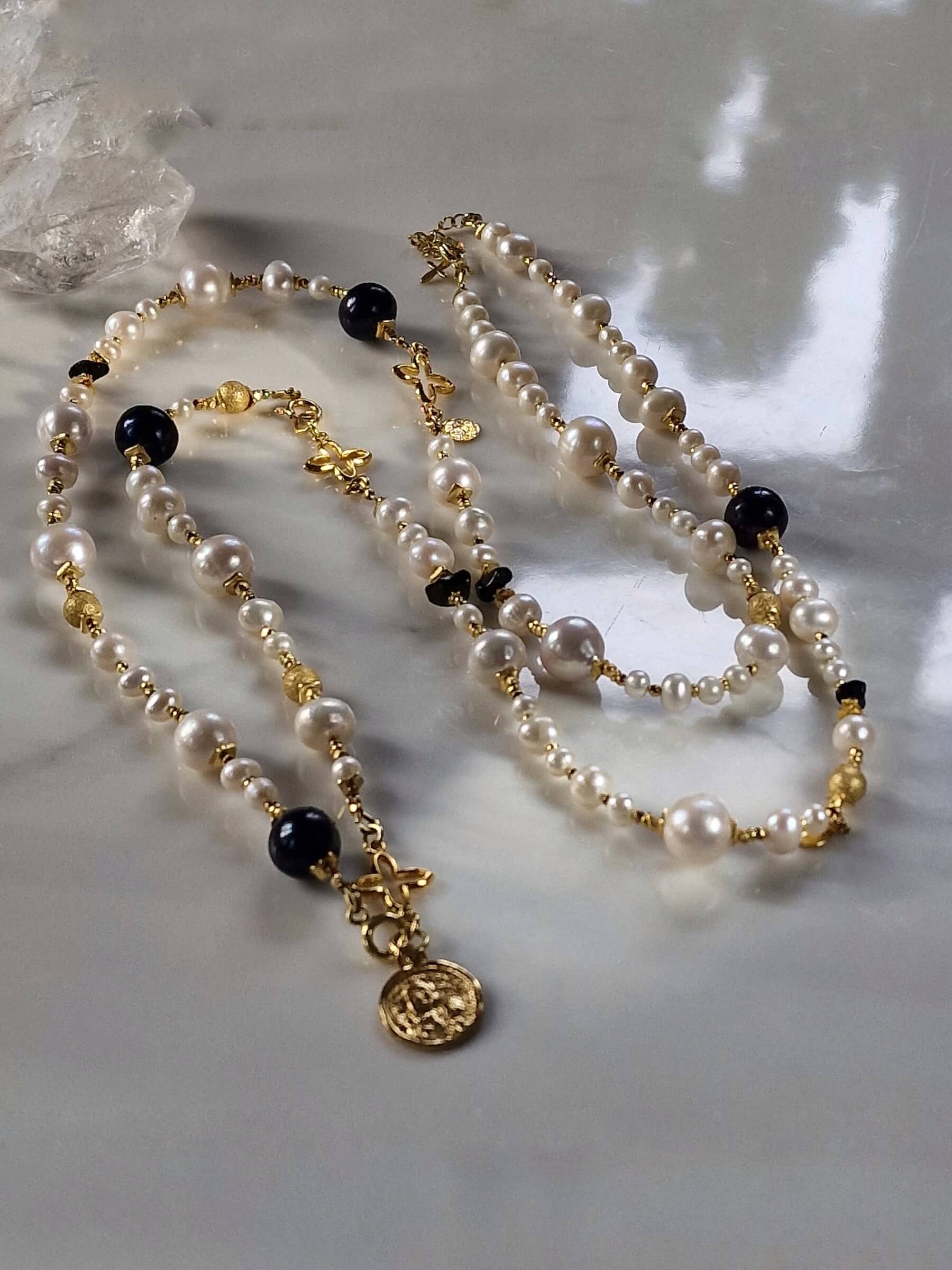 Packshot długiego naszyjnika z czarnych i białych pereł z bransoletką