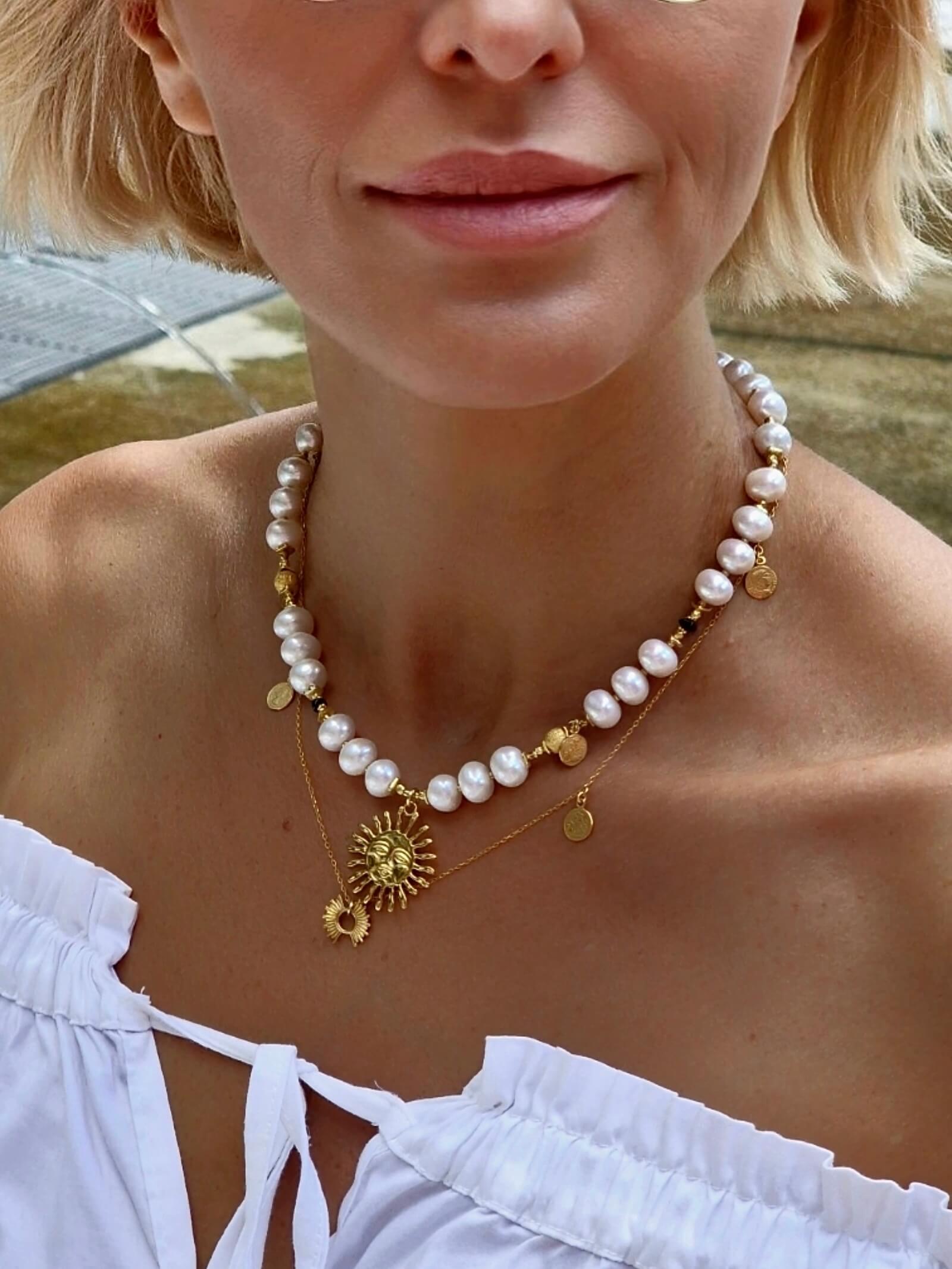 Zbliżenie na naszyjnik z białych pereł na modelce